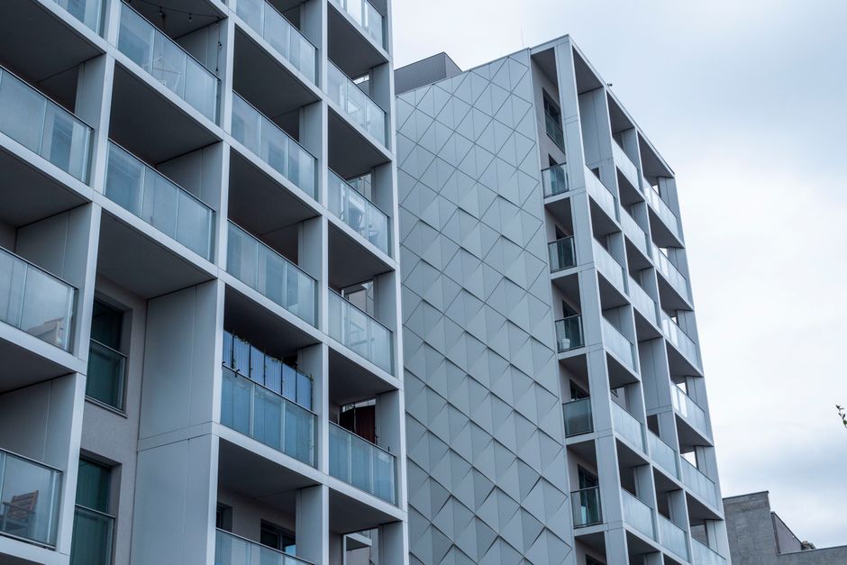 Contemporary glass facade of a city apartment building under a cloudy sky